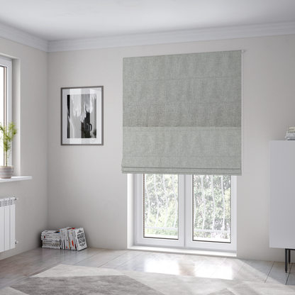 The fabric used to create these Roman blinds is a light silver-grey woven fabric with a fine, heathered texture.