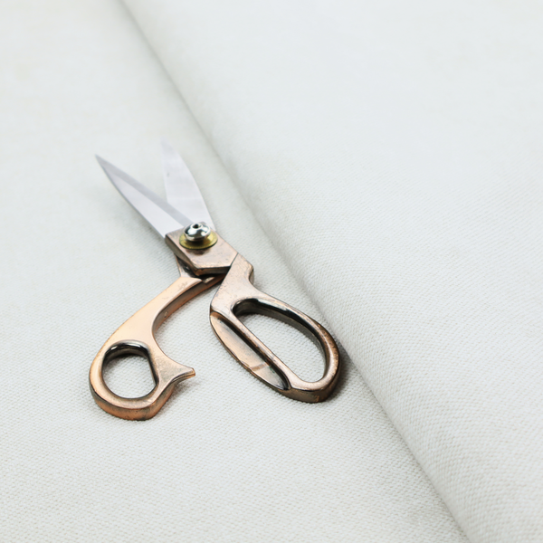 A solid, off-white or light cream-coloured woven fabric. The weave appears consistent and fine, creating a subtle, clean aesthetic.