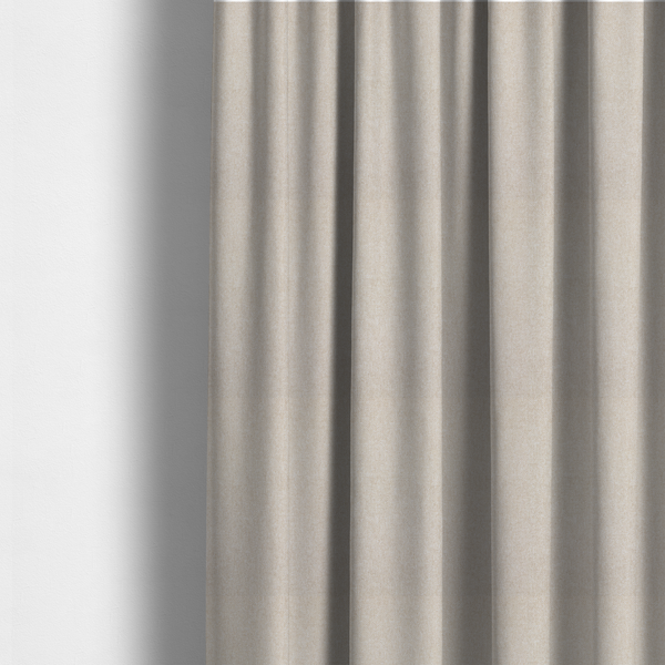 The fabric used to create these made-to-measure curtains is a woven upholstery fabric in a warm, light beige or sand colour, featuring a consistent, textured surface pattern.