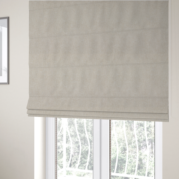 The fabric used to create these Roman blinds is a woven upholstery fabric in a warm, light beige or sand colour, featuring a consistent, textured surface pattern.