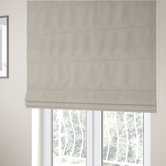 The fabric used to create these Roman blinds is a woven upholstery fabric in a warm, light beige or sand colour, featuring a consistent, textured surface pattern.
