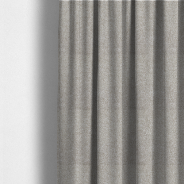 The fabric used to create these made-to-measure curtains is a woven upholstery fabric in a neutral, soft grey tone, featuring a consistent and textured surface pattern.