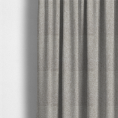 The fabric used to create these made-to-measure curtains is a woven upholstery fabric in a neutral, soft grey tone, featuring a consistent and textured surface pattern.