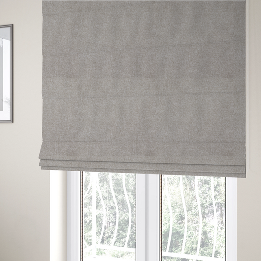 The fabric used to create these Roman blinds is a woven upholstery fabric in a neutral, soft grey tone, featuring a consistent and textured surface pattern.