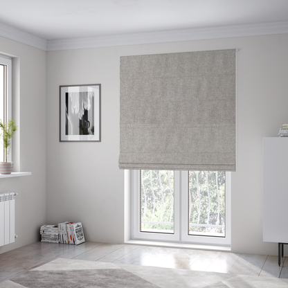 The fabric used to create these Roman blinds is a woven upholstery fabric in a neutral, soft grey tone, featuring a consistent and textured surface pattern.