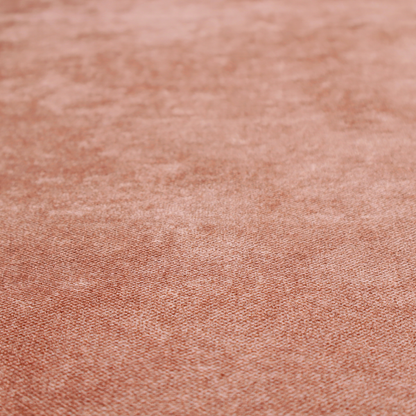 A fine, woven upholstery fabric in a warm, muted terracotta or copper tone, featuring a consistent and textured surface pattern.