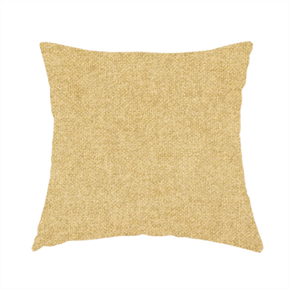 The fabric used to create this handmade cushion is a fine, woven upholstery fabric in a warm, golden yellow or ochre tone, featuring a consistent and textured surface pattern.