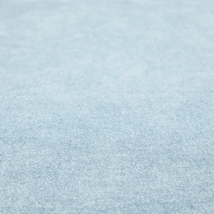 A fine, woven upholstery fabric in a soft, airy, powder blue tone, featuring a consistent and textured surface pattern.
