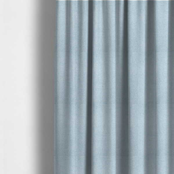 The fabric used to create these made-to-measure curtains is a fine, woven upholstery fabric in a soft, airy, powder blue tone, featuring a consistent and textured surface pattern.