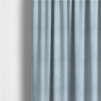 The fabric used to create these made-to-measure curtains is a fine, woven upholstery fabric in a soft, airy, powder blue tone, featuring a consistent and textured surface pattern.