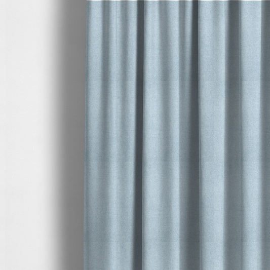 The fabric used to create these made-to-measure curtains is a fine, woven upholstery fabric in a soft, airy, powder blue tone, featuring a consistent and textured surface pattern.
