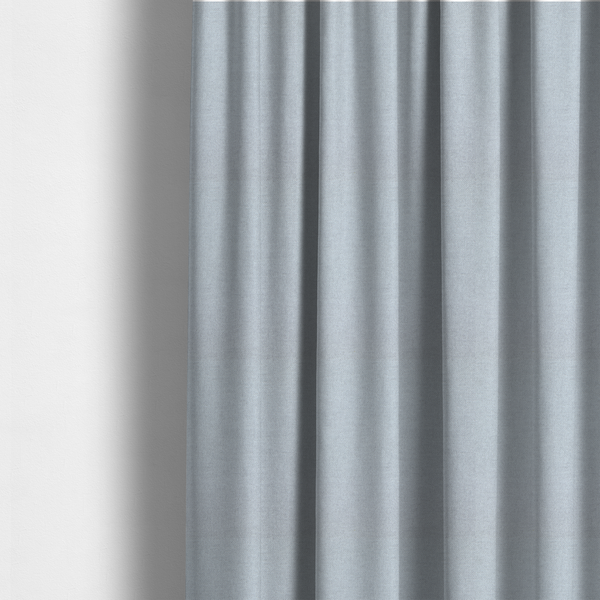 The fabric used to create these made-to-measure curtains is a fine, woven upholstery fabric in a subtle, cool-toned pale grey or off-white, featuring a consistent and textured surface pattern.