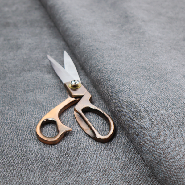 A fine, woven upholstery fabric in a deep, moody charcoal grey tone, featuring a consistent and textured surface pattern.