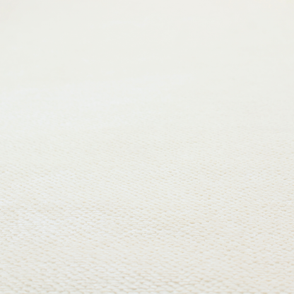 This image shows a close-up, high-resolution texture of a cream or off-white fabric. The material features a dense, uniform, boucle-style weave, characterized by small, looped, and nubby yarn fibres that create a soft, textured surface appearance.