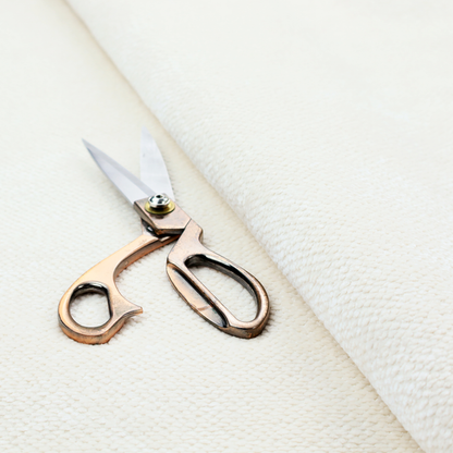 This image shows a close-up, high-resolution texture of a cream or off-white fabric. The material features a dense, uniform, boucle-style weave, characterized by small, looped, and nubby yarn fibres that create a soft, textured surface appearance.