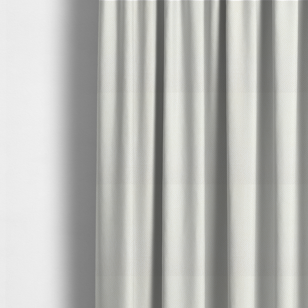 The fabric used to create these made-to-measure curtains is a cream or off-white fabric. The material features a dense, uniform, boucle-style weave, characterized by small, looped, and nubby yarn fibres that create a soft, textured surface appearance.