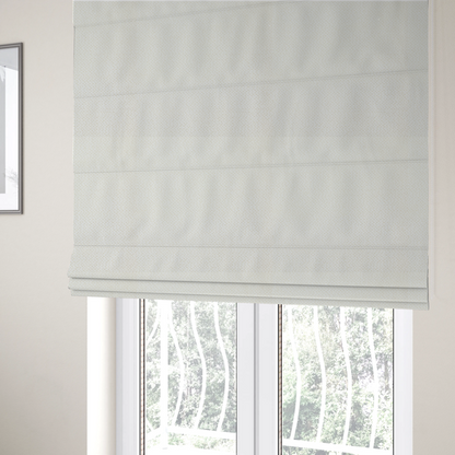 The fabric used to create these Roman blinds is a  cream or off-white fabric. The material features a dense, uniform, boucle-style weave, characterized by small, looped, and nubby yarn fibres that create a soft, textured surface appearance.