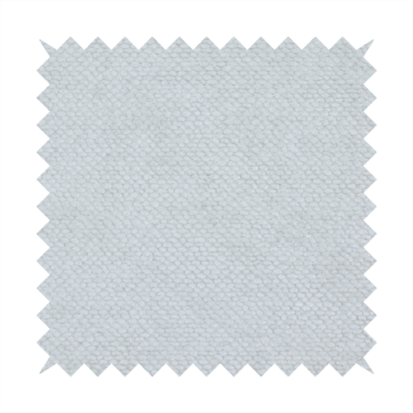 A cool-toned, light grey or silver upholstery fabric. It showcases the same dense, uniform, boucle-style weave seen in the previous image, consisting of small, looped, and nubby yarn fibres that create a soft, tactile surface.