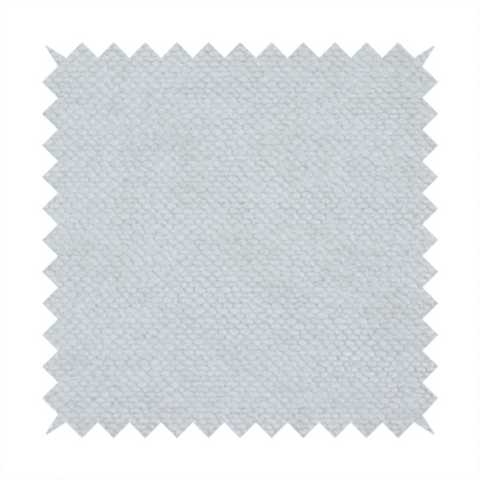 A cool-toned, light grey or silver upholstery fabric. It showcases the same dense, uniform, boucle-style weave seen in the previous image, consisting of small, looped, and nubby yarn fibres that create a soft, tactile surface.