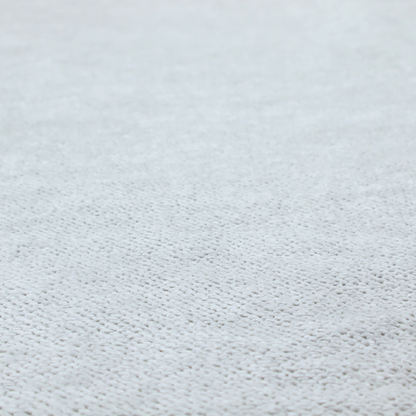 A cool-toned, light grey or silver upholstery fabric. It showcases the same dense, uniform, boucle-style weave seen in the previous image, consisting of small, looped, and nubby yarn fibres that create a soft, tactile surface.