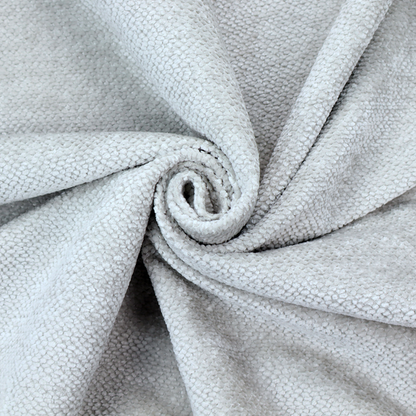 A cool-toned, light grey or silver upholstery fabric. It showcases the same dense, uniform, boucle-style weave seen in the previous image, consisting of small, looped, and nubby yarn fibres that create a soft, tactile surface.