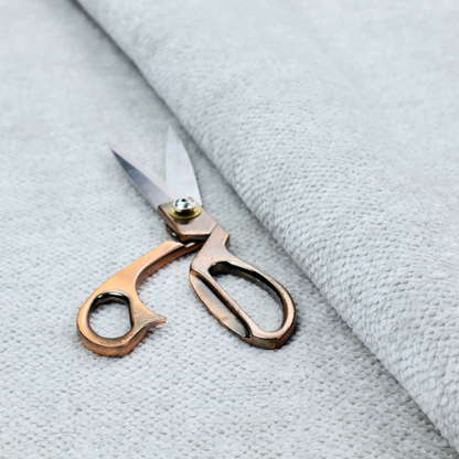 A cool-toned, light grey or silver upholstery fabric. It showcases the same dense, uniform, boucle-style weave seen in the previous image, consisting of small, looped, and nubby yarn fibres that create a soft, tactile surface.