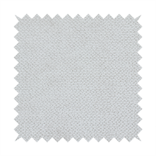 A light, neutral-toned upholstery fabric. It features the same signature dense, uniform, boucle-style weave as the previous samples, composed of small, looped, and nubby yarn fibres that provide a soft, tactile, and inviting surface.