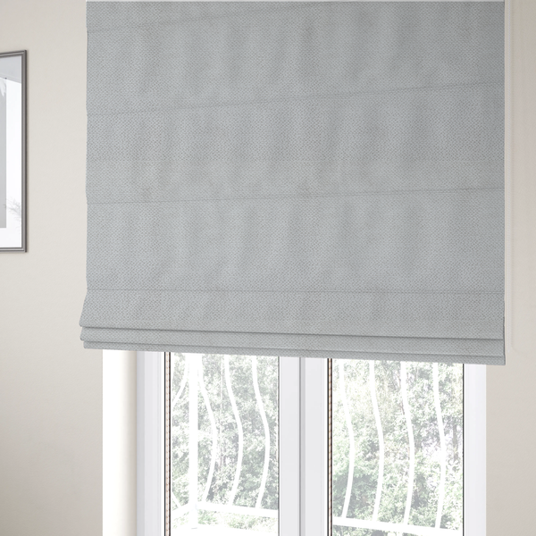 The fabric used to create these Roman blinds is a light, neutral-toned upholstery fabric. It features the same signature dense, uniform, boucle-style weave as the previous samples, composed of small, looped, and nubby yarn fibres that provide a soft, tactile, and inviting surface.