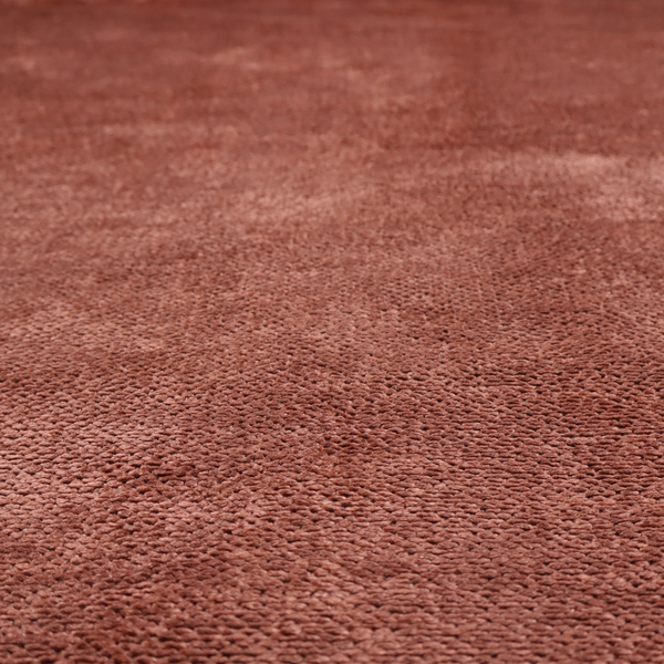 A rich, terracotta or rust-toned upholstery fabric. It maintains the signature dense, uniform, boucle-style weave featured in the collection, composed of small, looped, and nubby yarn fibres that provide a soft and tactile surface.