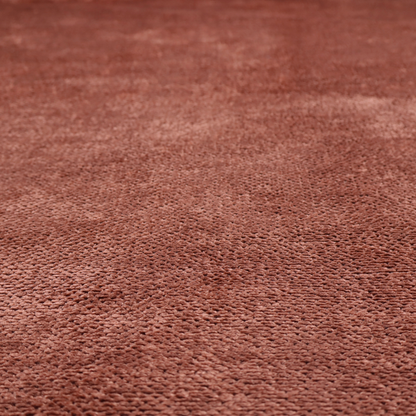 A rich, terracotta or rust-toned upholstery fabric. It maintains the signature dense, uniform, boucle-style weave featured in the collection, composed of small, looped, and nubby yarn fibres that provide a soft and tactile surface.