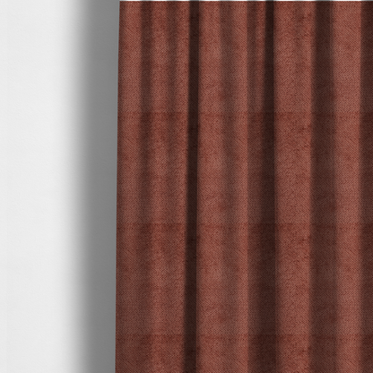 The fabric used to create these made-to-measure curtains is a rich, terracotta or rust-toned upholstery fabric. It maintains the signature dense, uniform, boucle-style weave featured in the collection, composed of small, looped, and nubby yarn fibres that provide a soft and tactile surface.