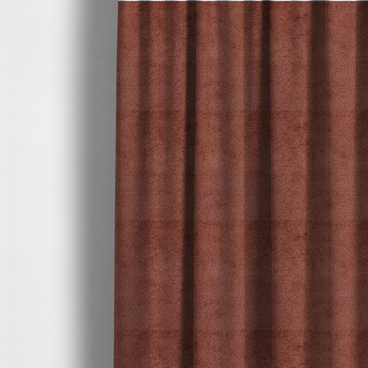 The fabric used to create these made-to-measure curtains is a rich, terracotta or rust-toned upholstery fabric. It maintains the signature dense, uniform, boucle-style weave featured in the collection, composed of small, looped, and nubby yarn fibres that provide a soft and tactile surface.
