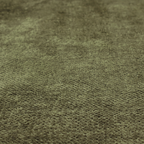 A deep, earth-toned olive green upholstery fabric. It continues the signature dense, uniform, boucle-style weave of the collection, created with small, looped, and nubby yarn fibres that offer a soft and tactile surface.