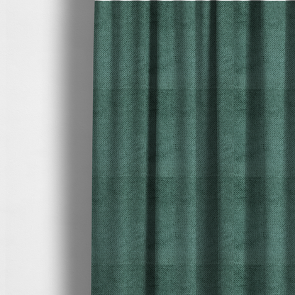 The fabric used to create these made-to-measure curtains is a deep, rich teal or blue-green upholstery fabric. It maintains the signature dense, uniform, boucle-style weave of the collection, composed of small, looped, and nubby yarn fibres that create a soft and tactile surface.