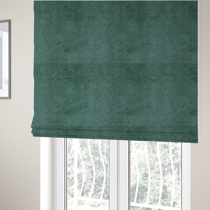 The fabric used to create these Roman blinds is a deep, rich teal or blue-green upholstery fabric. It maintains the signature dense, uniform, boucle-style weave of the collection, composed of small, looped, and nubby yarn fibres that create a soft and tactile surface.