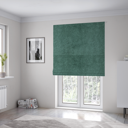 The fabric used to create these Roman blinds is a deep, rich teal or blue-green upholstery fabric. It maintains the signature dense, uniform, boucle-style weave of the collection, composed of small, looped, and nubby yarn fibres that create a soft and tactile surface.
