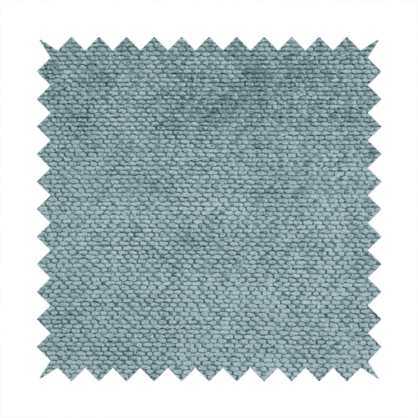 A cool, muted blue or slate-toned upholstery fabric. It features the same signature dense, uniform, boucle-style weave as the previous samples, characterized by small, looped, and nubby yarn fibres that create a soft and tactile surface.