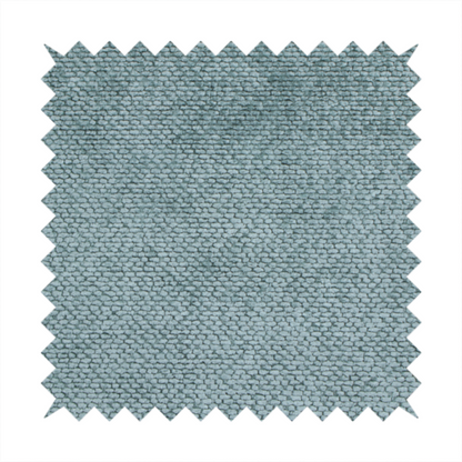A cool, muted blue or slate-toned upholstery fabric. It features the same signature dense, uniform, boucle-style weave as the previous samples, characterized by small, looped, and nubby yarn fibres that create a soft and tactile surface.