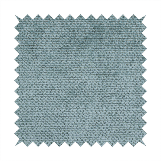 A cool, muted blue or slate-toned upholstery fabric. It features the same signature dense, uniform, boucle-style weave as the previous samples, characterized by small, looped, and nubby yarn fibres that create a soft and tactile surface.