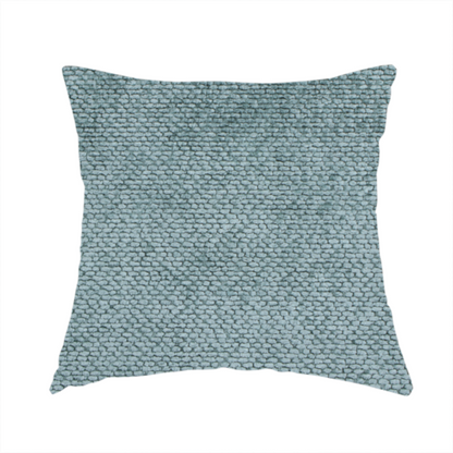 The fabric used to create this handmade cushion is a cool, muted blue or slate-toned upholstery fabric. It features the same signature dense, uniform, boucle-style weave as the previous samples, characterized by small, looped, and nubby yarn fibres that create a soft and tactile surface.