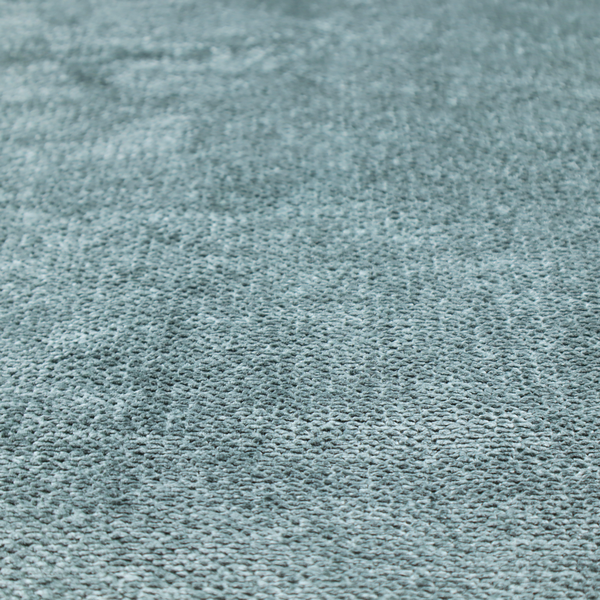 A cool, muted blue or slate-toned upholstery fabric. It features the same signature dense, uniform, boucle-style weave as the previous samples, characterized by small, looped, and nubby yarn fibres that create a soft and tactile surface.