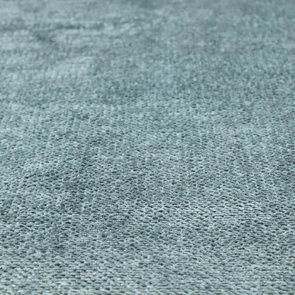 A cool, muted blue or slate-toned upholstery fabric. It features the same signature dense, uniform, boucle-style weave as the previous samples, characterized by small, looped, and nubby yarn fibres that create a soft and tactile surface.