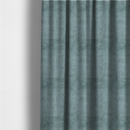 The fabric used to create these made-to-measure curtains is a cool, muted blue or slate-toned upholstery fabric. It features the same signature dense, uniform, boucle-style weave as the previous samples, characterized by small, looped, and nubby yarn fibres that create a soft and tactile surface.