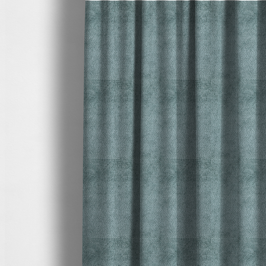 The fabric used to create these made-to-measure curtains is a cool, muted blue or slate-toned upholstery fabric. It features the same signature dense, uniform, boucle-style weave as the previous samples, characterized by small, looped, and nubby yarn fibres that create a soft and tactile surface.