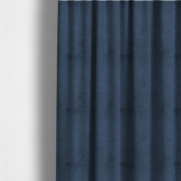 The fabric used to create these made-to-measure curtains is a deep, rich navy blue upholstery fabric. It features the signature dense, uniform, boucle-style weave of the collection, composed of small, looped, and nubby yarn fibres that create a soft and tactile surface.