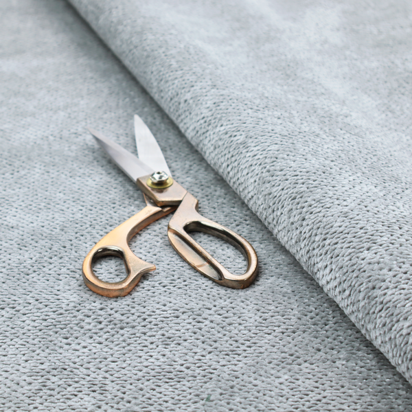 A soft, light-toned, cool-grey upholstery fabric. It features the signature dense, uniform, boucle-style weave of the collection, created with small, looped, and nubby yarn fibres that offer a comfortable, tactile surface.