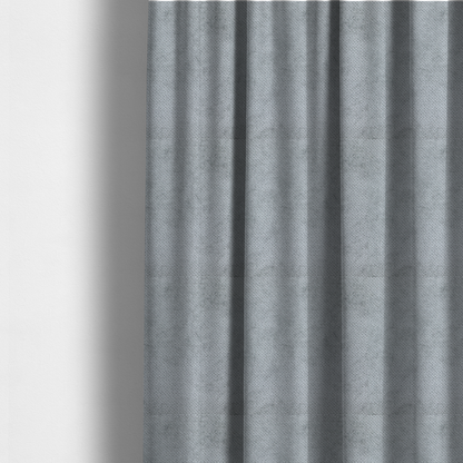 The fabric used to create these made-to-measure curtains is a soft, light-toned, cool-grey upholstery fabric. It features the signature dense, uniform, boucle-style weave of the collection, created with small, looped, and nubby yarn fibres that offer a comfortable, tactile surface.