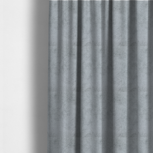The fabric used to create these made-to-measure curtains is a soft, light-toned, cool-grey upholstery fabric. It features the signature dense, uniform, boucle-style weave of the collection, created with small, looped, and nubby yarn fibres that offer a comfortable, tactile surface.