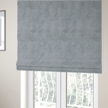 The fabric used to create these Roman blinds is a soft, light-toned, cool-grey upholstery fabric. It features the signature dense, uniform, boucle-style weave of the collection, created with small, looped, and nubby yarn fibres that offer a comfortable, tactile surface.