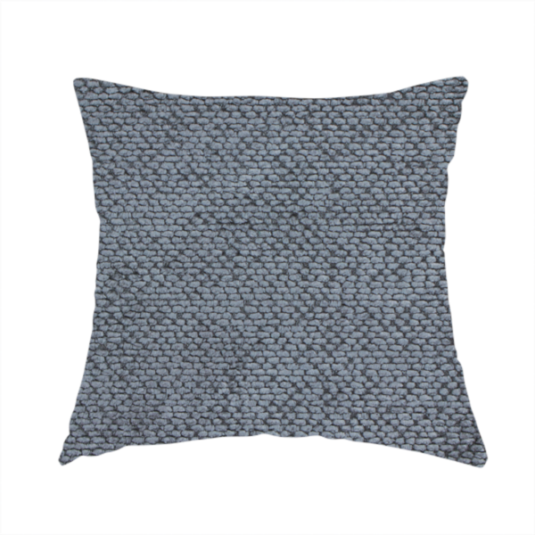 The fabric used to create this handmade cushion is a deep, moody charcoal or slate-grey upholstery fabric. It maintains the signature dense, uniform, boucle-style weave of the collection, composed of small, looped, and nubby yarn fibres that provide a soft and tactile surface.